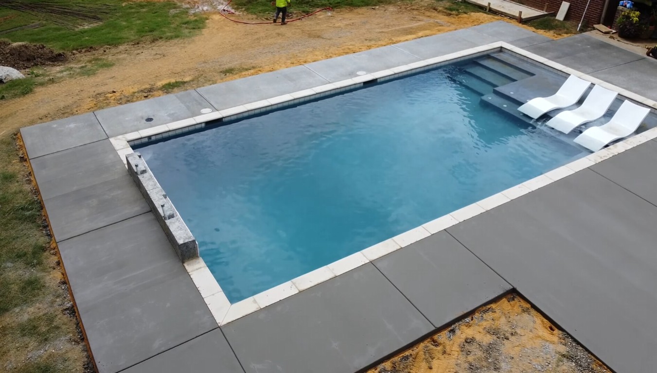 Modern concrete pool deck surrounding swimming pool in Calexico, CA